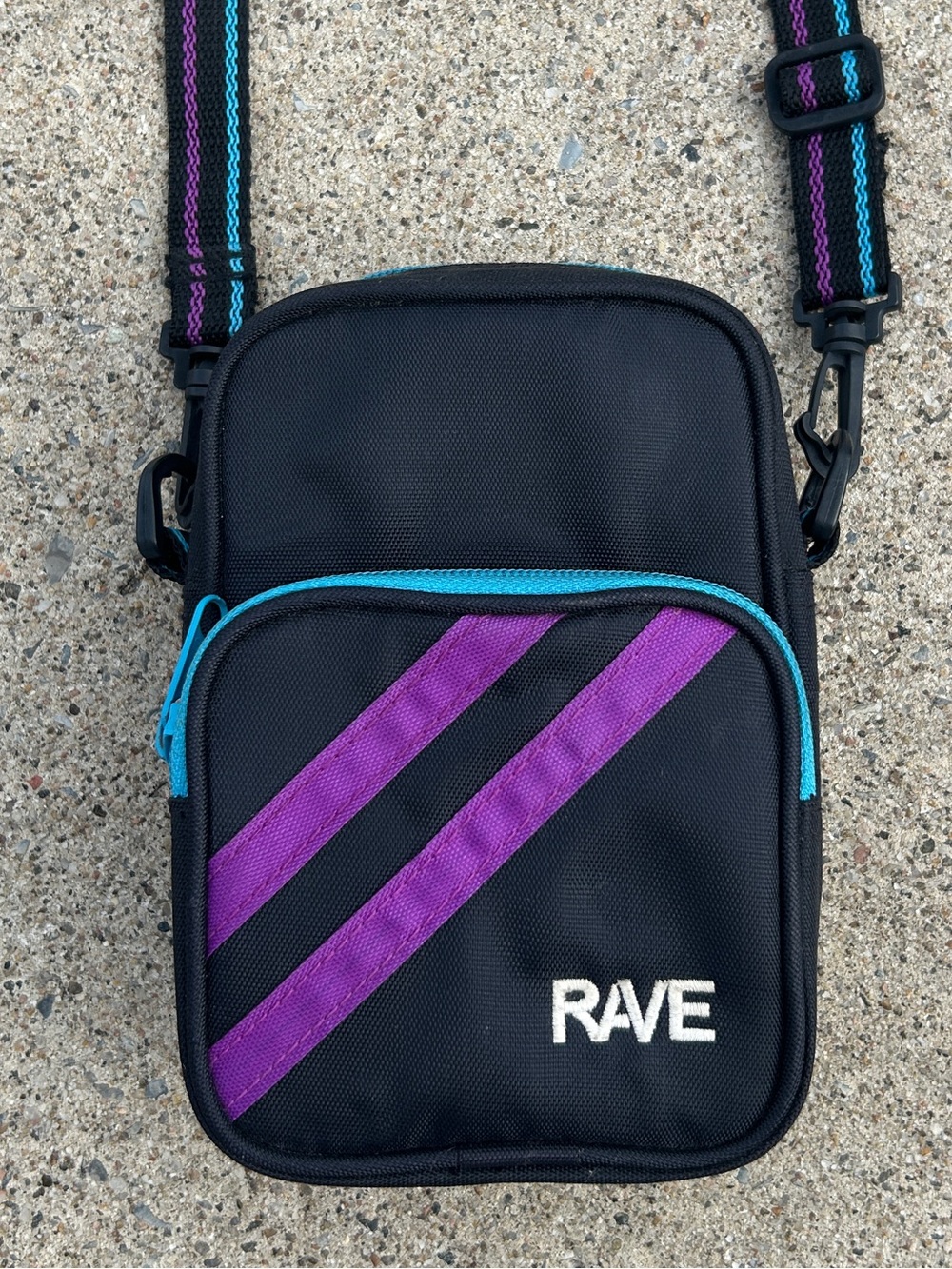 Rave Black Crossbody Bag with Purple and Teal Stripes.